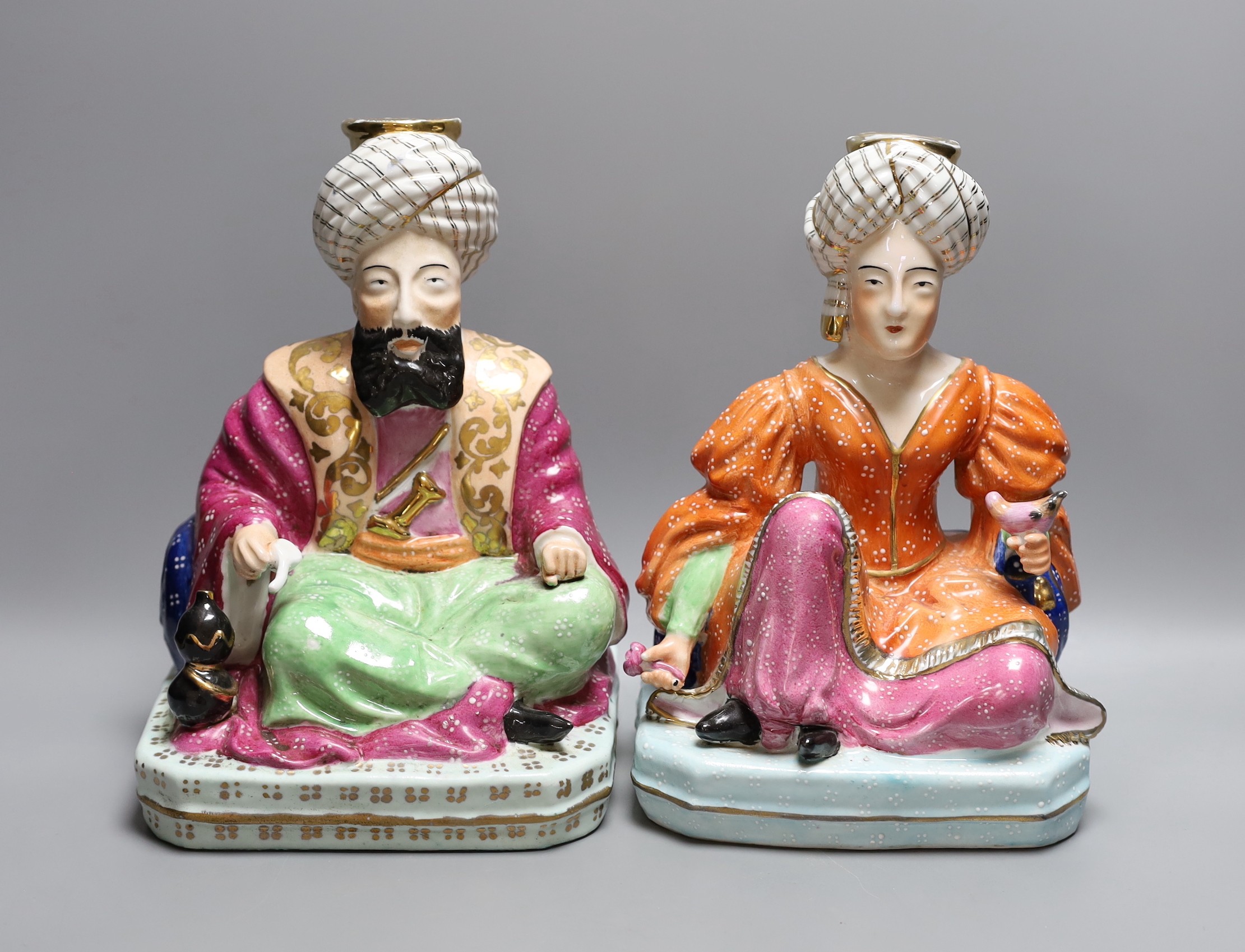 A pair of Jacob Petit style porcelain dressing table scent bottles, modelled as seated Turks, 26cm